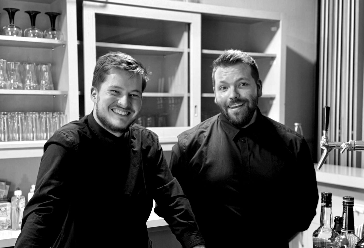 Christopher und Tobias Aßmann, die Gründer von CheersMates, hinter der Bar